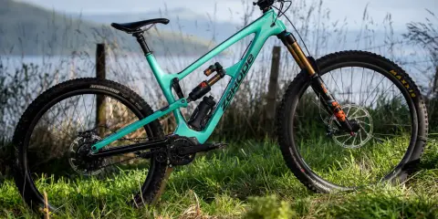Turkusowy rower full-suspension marki Zerode, gotowy na górskie trasy. Wśród wielu marek rowerów, ten wyróżnia się designem.