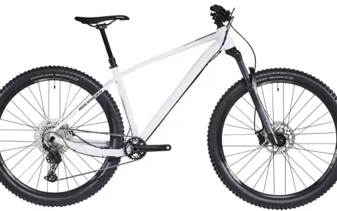 Biały rower hardtail z czarnymi oponami i amortyzatorem RockShox. Idealny na górskie trasy.