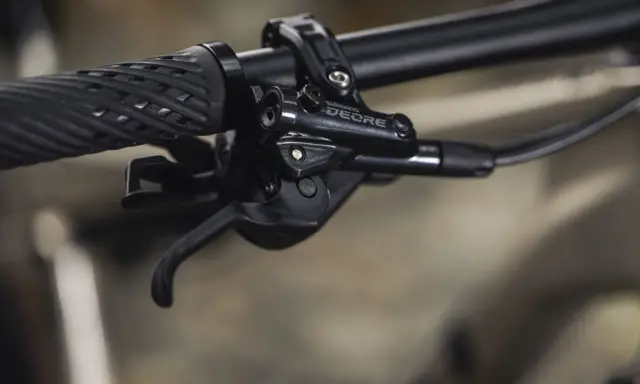 Manetka Shimano Deore, część mechanizmu zmiany biegów, pokazuje różne rodzaje przerzutek rowerowych w akcji.