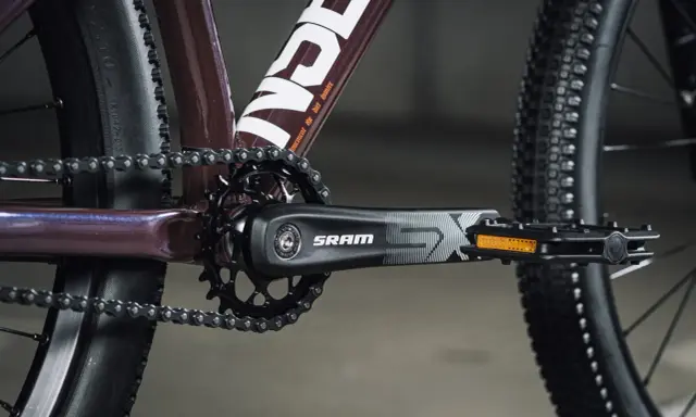 Zbliżenie na rowerowy mechanizm korbowy SRAM i łańcuch. Tabela przełożeń rowerowych jest kluczowa dla płynnej jazdy.