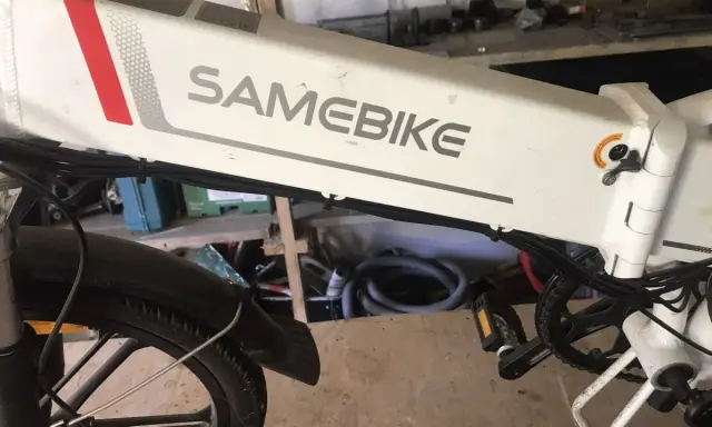 Biały rower elektryczny SAMEBIKE, z widocznym napisem marki. Wspomaganie nie działa, co jest problemem dla właściciela.