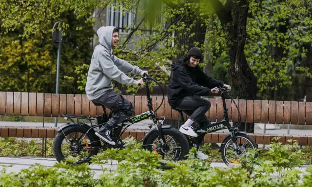 Dwie osoby cieszą się jazdą na rowerach elektrycznych. Dofinansowanie do roweru elektrycznego sprawia, że takie wycieczki są dostępne dla każdego.