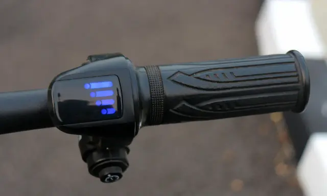 Manetka gazu w rowerze elektrycznym z niebieskim wskaźnikiem baterii. Obracając ją, kontrolujesz prędkość.