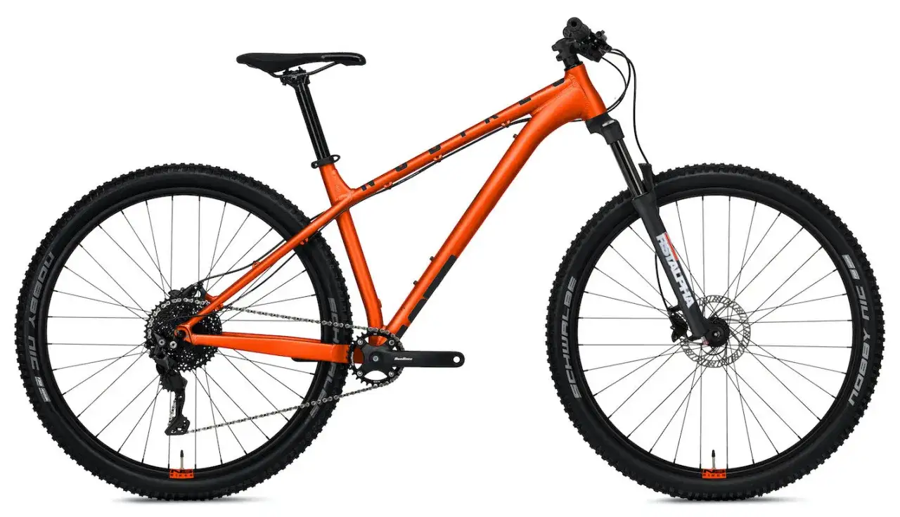 Pomarańczowy rower g&oacute;rski z amortyzowanym widelcem. Czy to hardtail czy full? Ten model to klasyczny hardtail, gotowy na wyzwania.