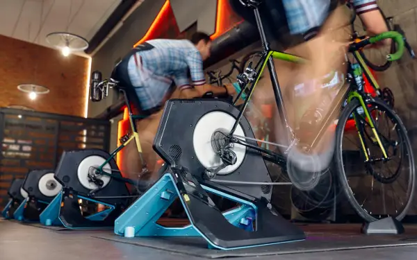 Intensywna jazda na rowerze w domu. Kilka rowerów stacjonarnych z trenażerami w akcji, tworząc wrażenie ruchu.